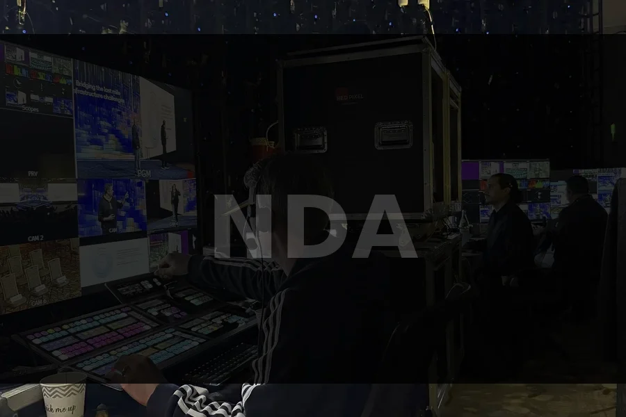 Operator monitoring signal flow on multi-screen desk